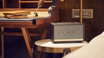 A desk with a vintage Marantz speaker, a feather quill, and books, suggesting a study or work area.