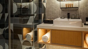 A modern bathroom with a glass shower enclosure, a large mirror, and a vanity with a sink and towel racks. - Macalister Hotel Managed By The Ascott Limited (George Town)