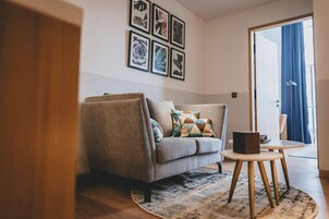 Una sala de estar moderna con un sofá gris, una mesa de centro redonda y un tapete estampado.