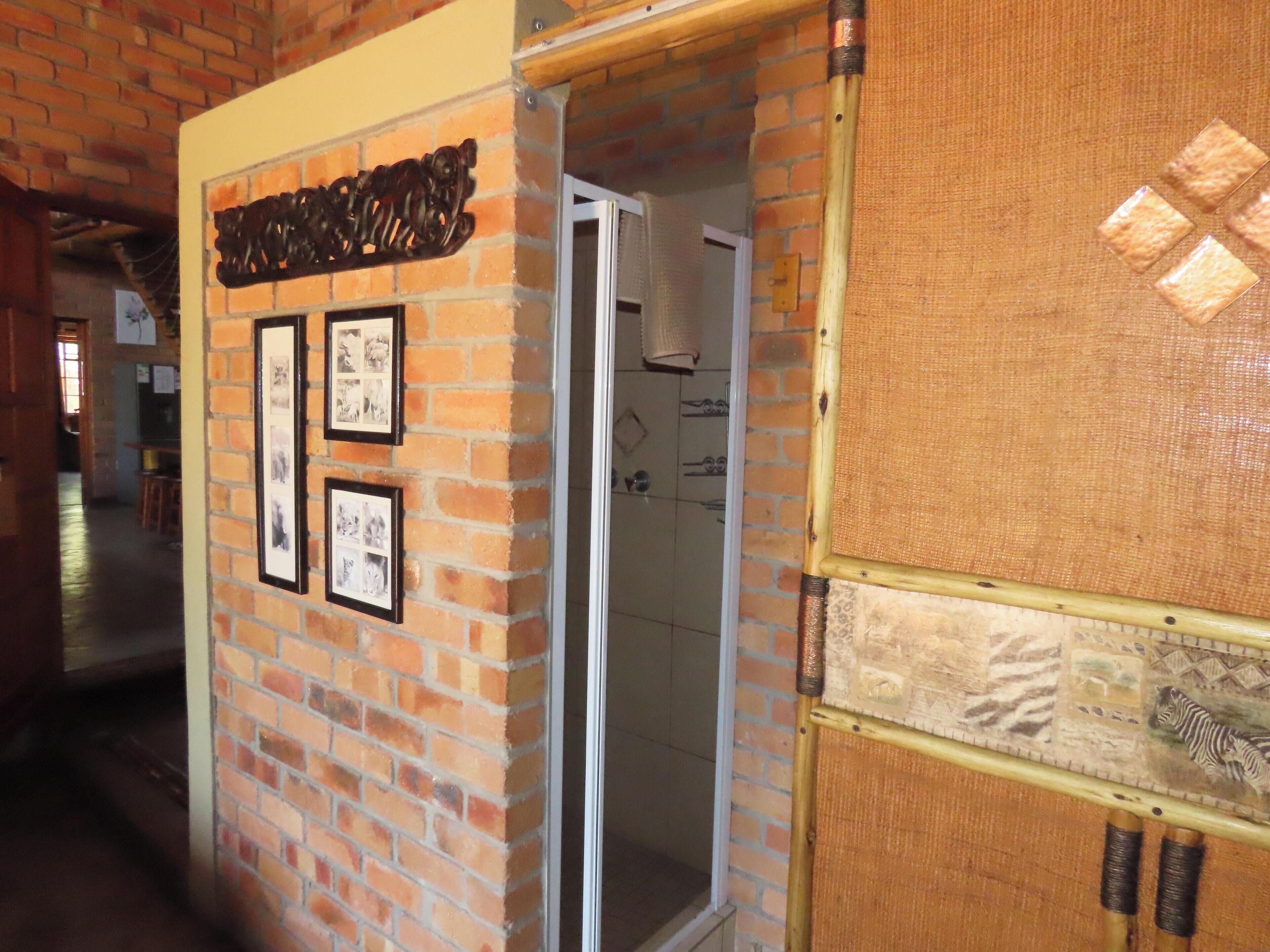 Un mur de briques orné de tableaux encadrés et d’une enseigne en bois.