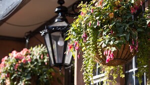A building with hanging flower baskets and a traditional black lantern. - The Cross Keys (Knutsford)