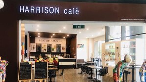El interior del Harrison Café, con un tablero de menú, zona de estar y una barra.