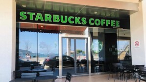 Fachada de Starbucks Coffee con mesas al aire libre.