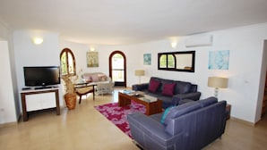 Ein Wohnzimmer mit Sofa, Couchtisch, Fernseher und Dekorationselementen.