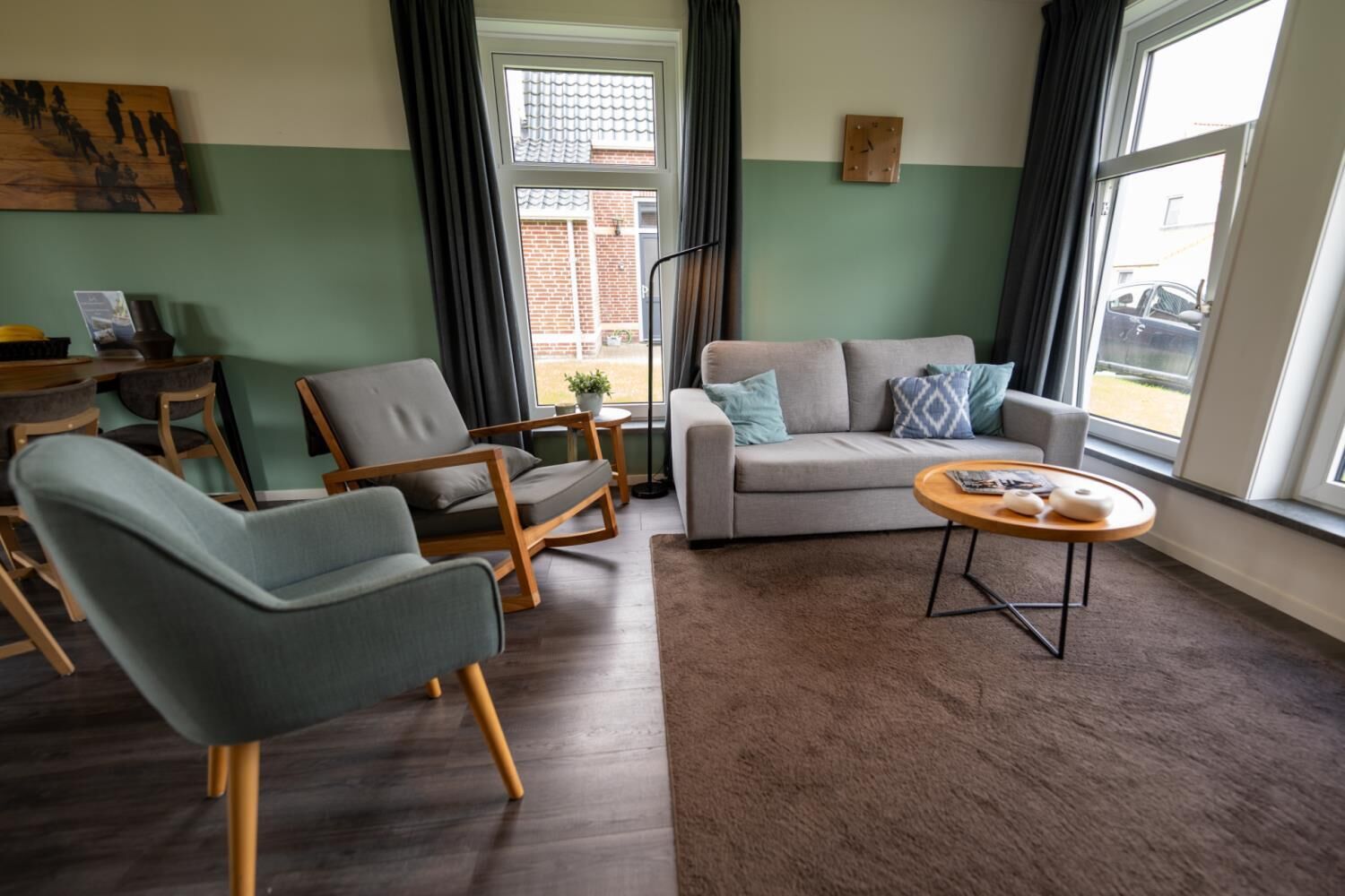 A living room with a sofa, two armchairs, a coffee table, and a small side table.