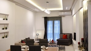 A modern living room with a dining area, a sofa set, and a TV.