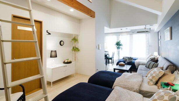Una habitación moderna con cama elevada, escritorio y zona de comedor.