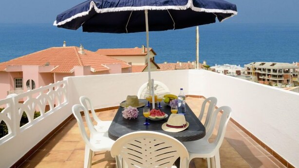 Ein Balkon mit Tisch für zwei Personen, mit Blick auf das Meer.