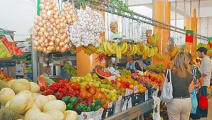 Ein Lebensmittelgeschäft mit einer Auswahl an Obst und Gemüse, darunter Bananen, Äpfel und Paprika.