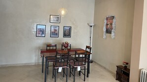 Un comedor con una mesa y sillas, una lámpara colgante y cuadros en la pared.
