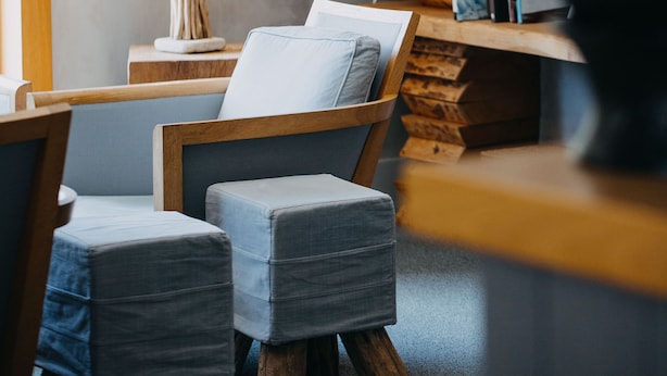 Un rincón acogedor para leer, con una silla, una mesita y una lámpara.