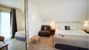 Un dormitorio con cama, mesitas de noche, una silla y una pequeña mesa.