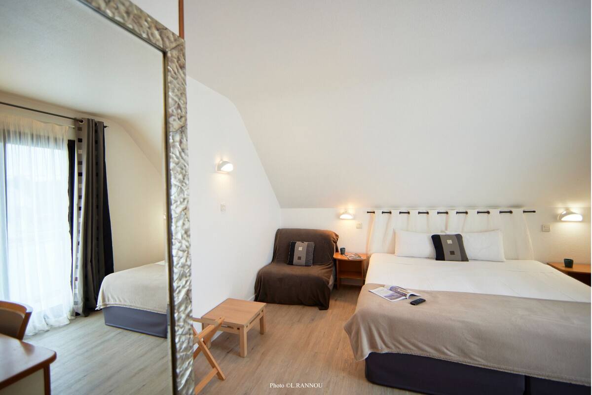 A bedroom with a bed, bedside tables, a chair, and a small table.