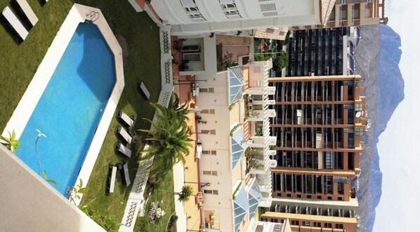 A hotel with a swimming pool, a covered outdoor area, and a view of mountains. - Ballesol Costablanca Senior Resort mayores de 55 (Villajoyosa)