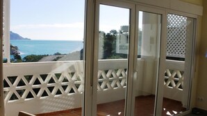 Uma varanda com vista para o mar e montanhas.