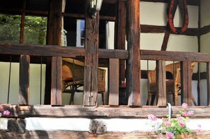 A rustic wooden fence with a white wall and a wooden door in the background. - Hotel Mohrenbrunnen (Eisenberg)