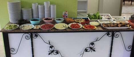 A buffet setup with various food items and condiments.