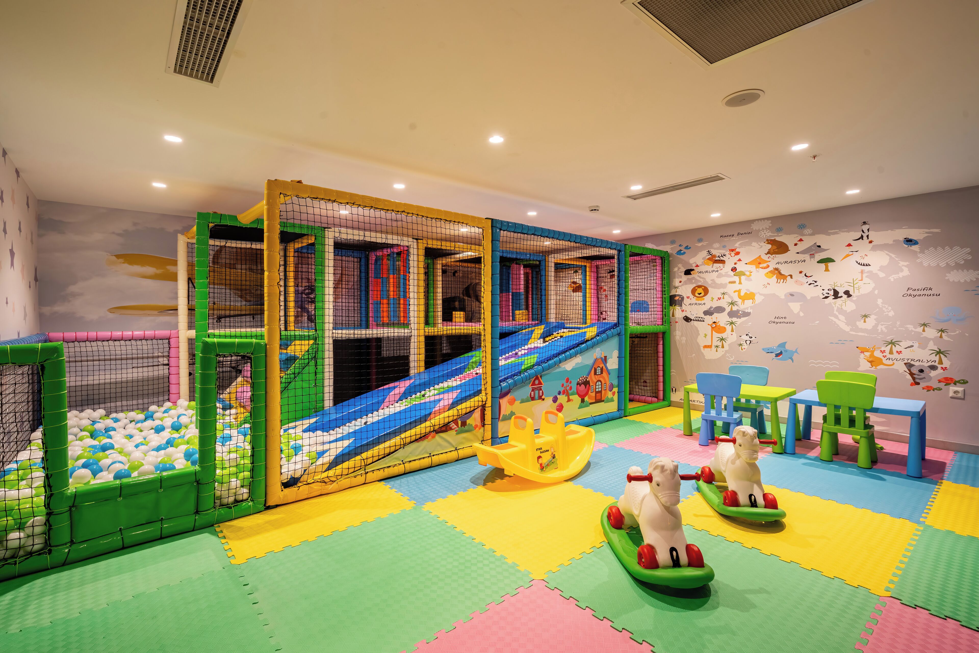 A children's play area with a ball pit, slides, and colorful play structures.