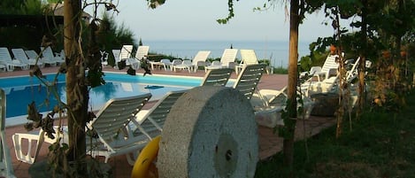 Piscine extérieure, parasols de plage, chaises longues