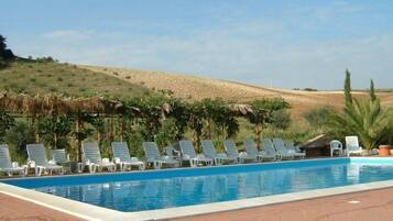 Een buitenzwembad, parasols voor strand/zwembad