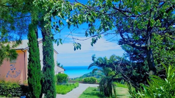 Um caminho que leva a um edifício com vista para o mar.
