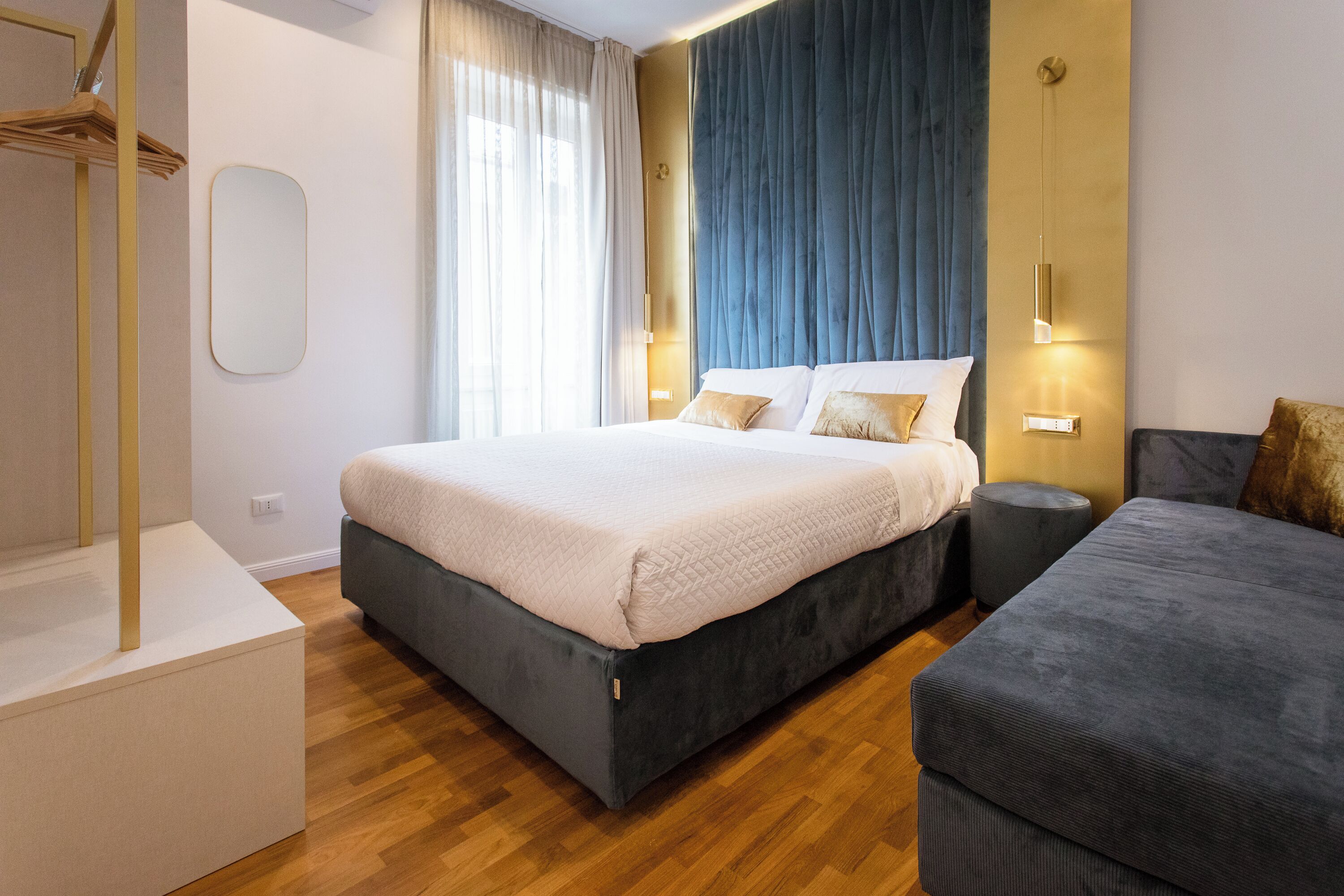 Un dormitorio moderno con una cama grande, una mesita de noche, un armario y una pequeña mesa redonda.