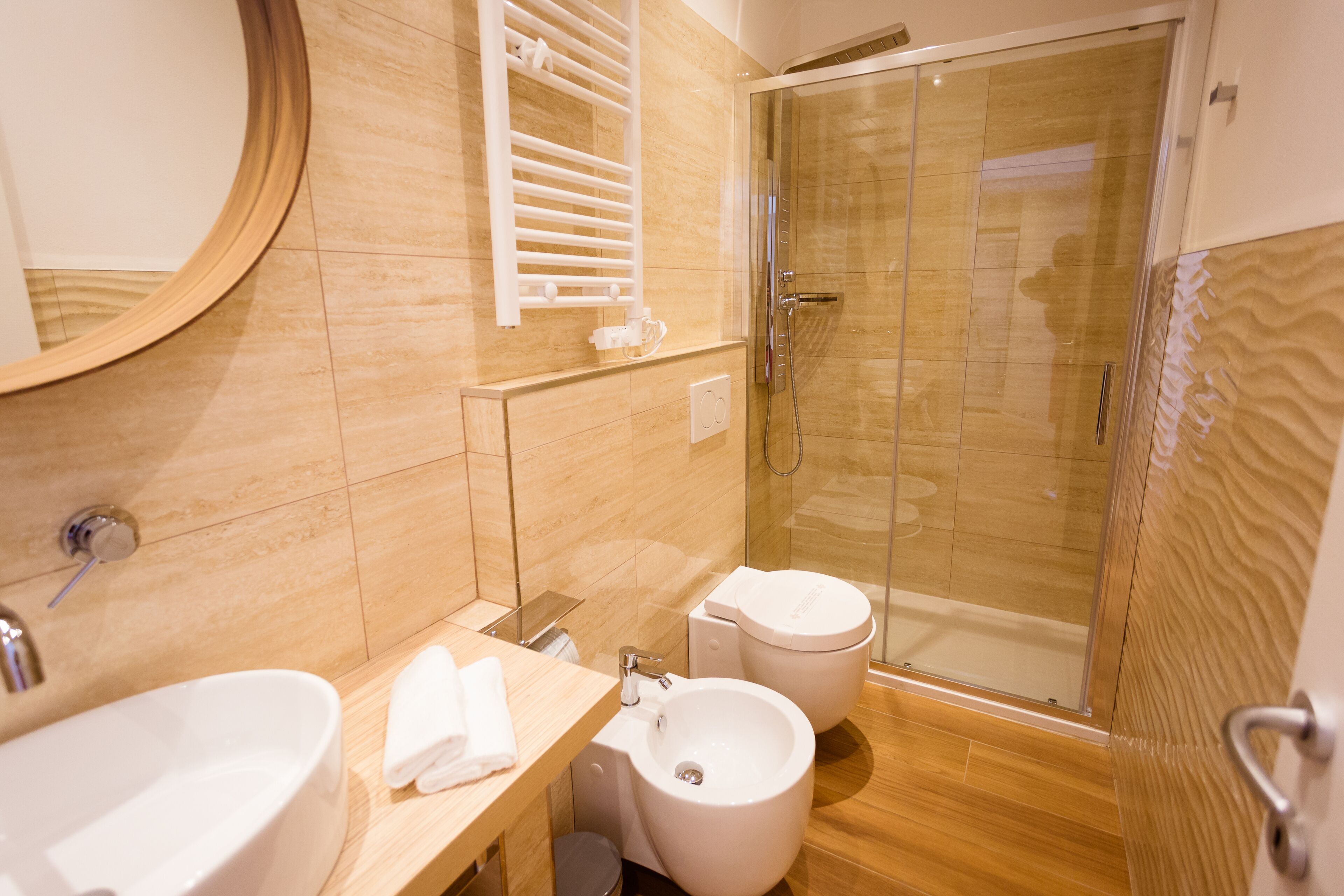 Ein modernes Badezimmer mit Waschbecken, Bidet und Duschkabine.