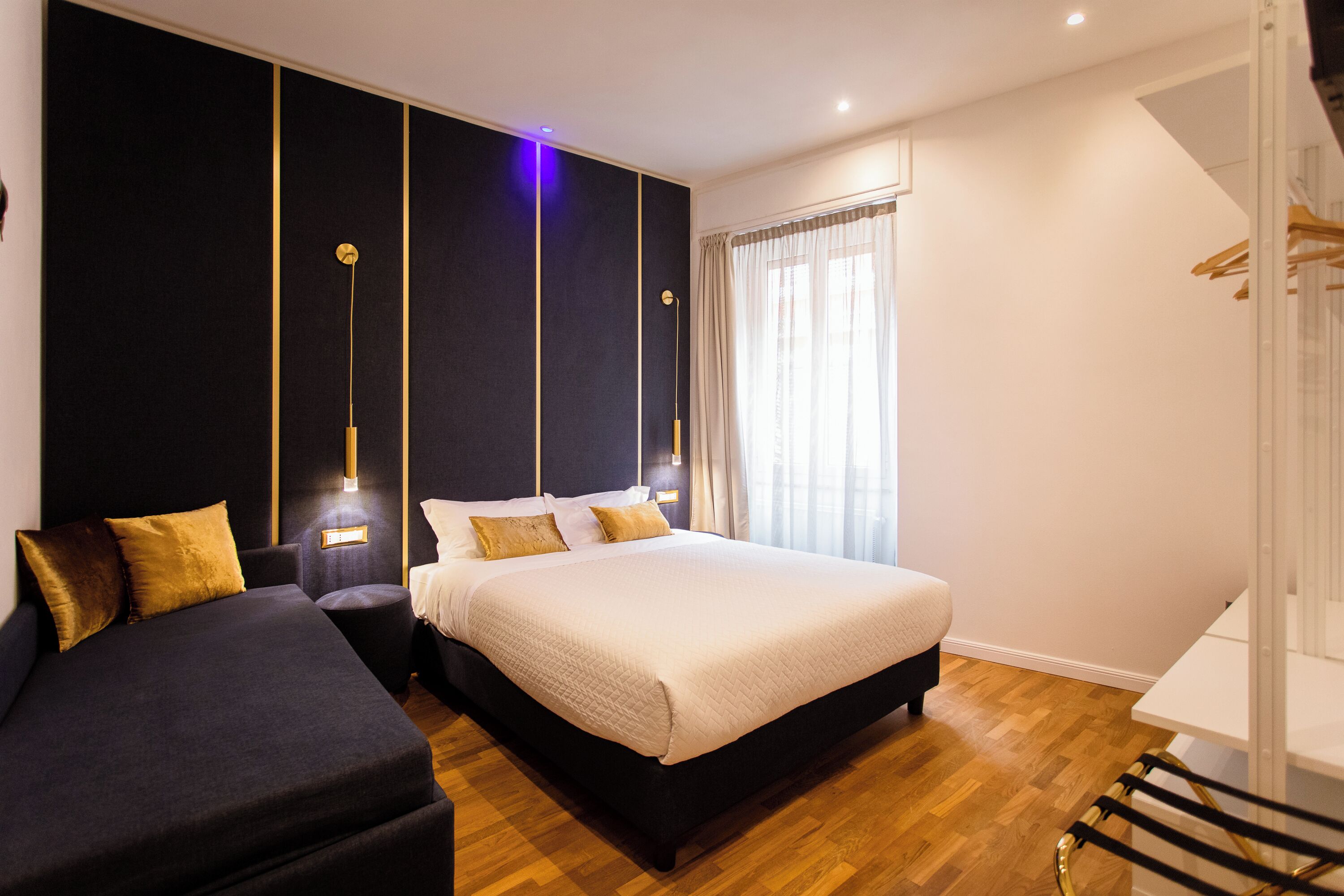 Een moderne slaapkamer met een groot bed, een bank en een bureau.