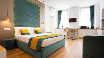 Une chambre d’hôtel moderne dotée d’un grand lit, d’un bureau et d’une kitchenette.