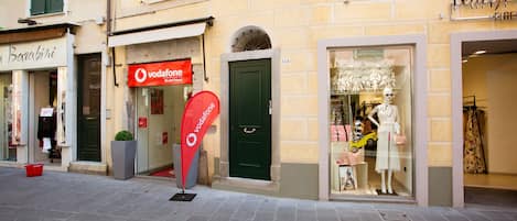 Un escaparate con un letrero de Vodafone, un maniquí en la vitrina y una puerta con el número 144.