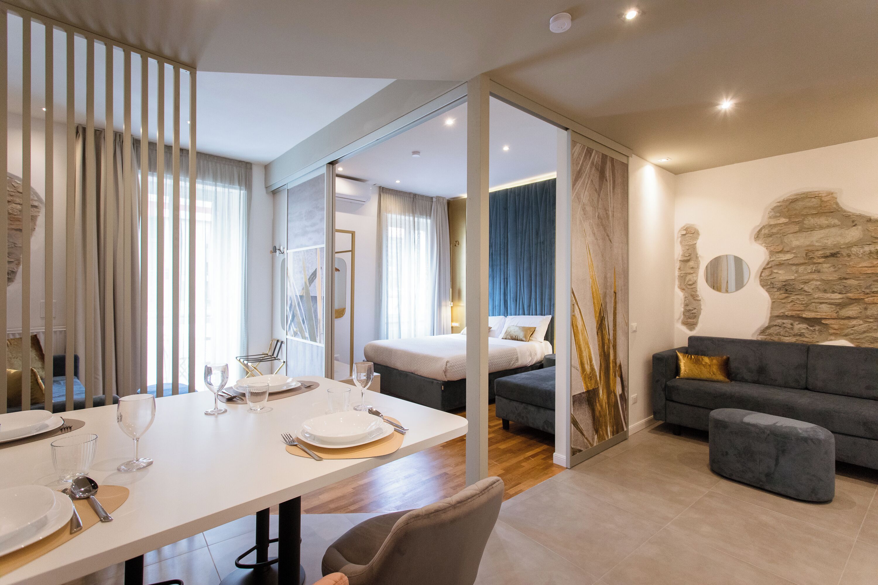 Ein modernes Hotelzimmer mit Essbereich, einer Couch und einem Bett.