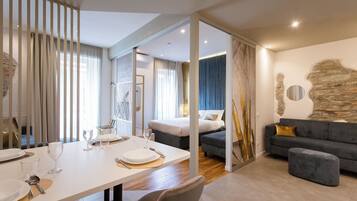 Ein modernes Hotelzimmer mit Essbereich, einer Couch und einem Bett.