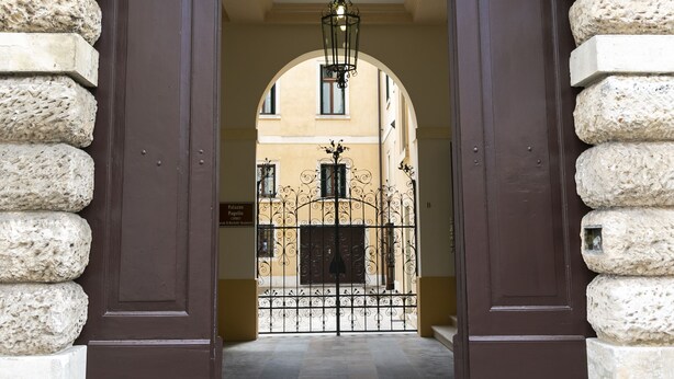 The entrance to Palazzo Scamozzi Hotel - Vicenza, featuring a stone archway and a dark brown door. - Palazzo Scamozzi (Vicenza)