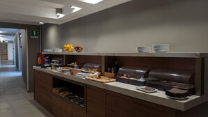 A buffet area with various food items, a coffee station, and a juice dispenser. - Palazzo Scamozzi (Vicenza)