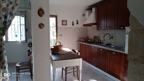 Une cuisine avec des meubles de rangement en bois, un évier et une fenêtre.