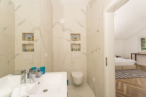 Luxe appartement, Meerdere bedden, uitzicht op zee | Badkamer | Een haardroger, handdoeken, zeep, shampoo
