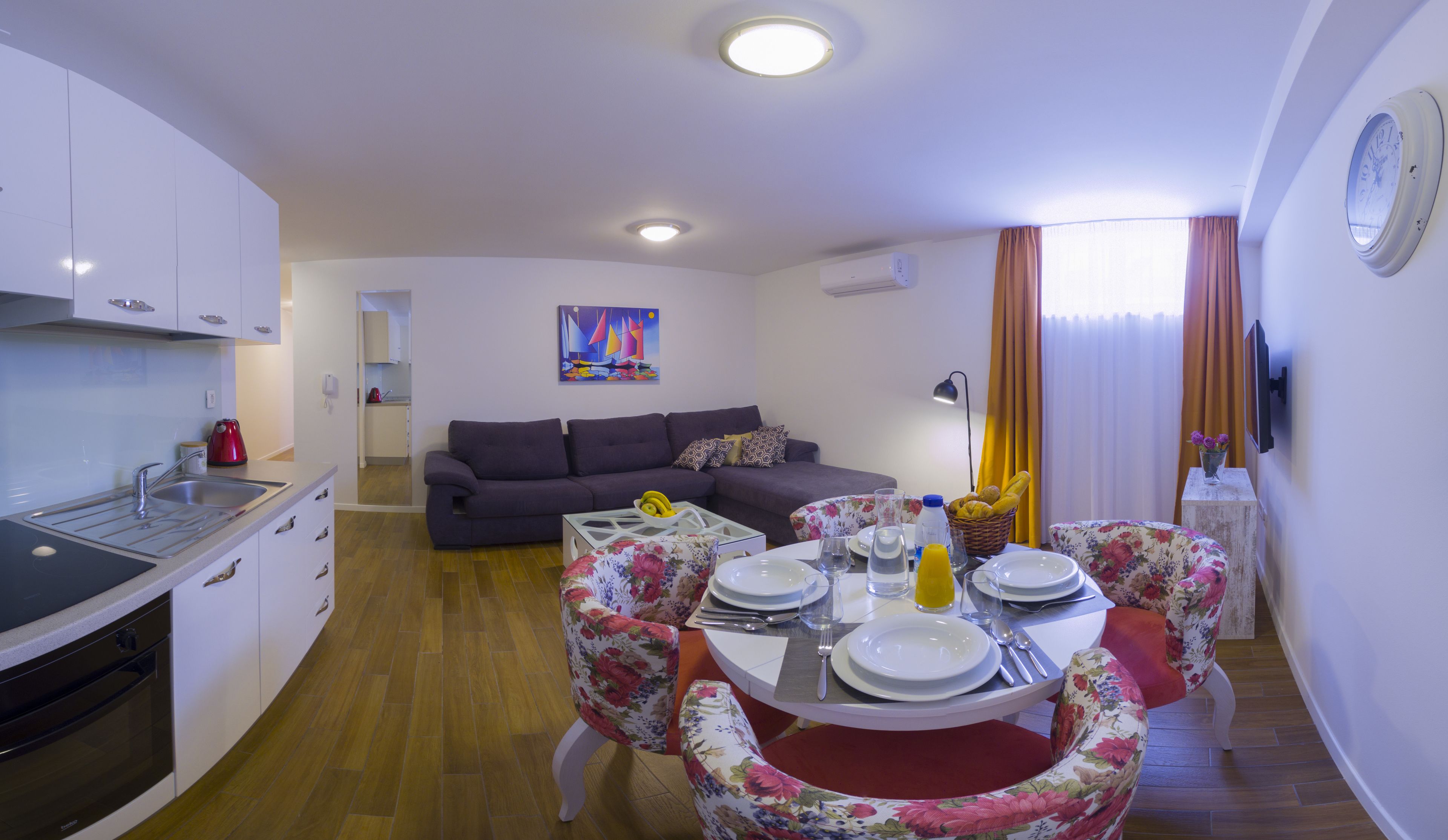 A compact living space with a kitchen, dining area, and a sofa.