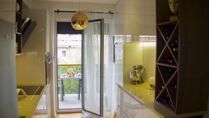 A modern kitchen with a dining area, a balcony with a view, and a wine rack. - Presidential Suites Chica Cure (Split)