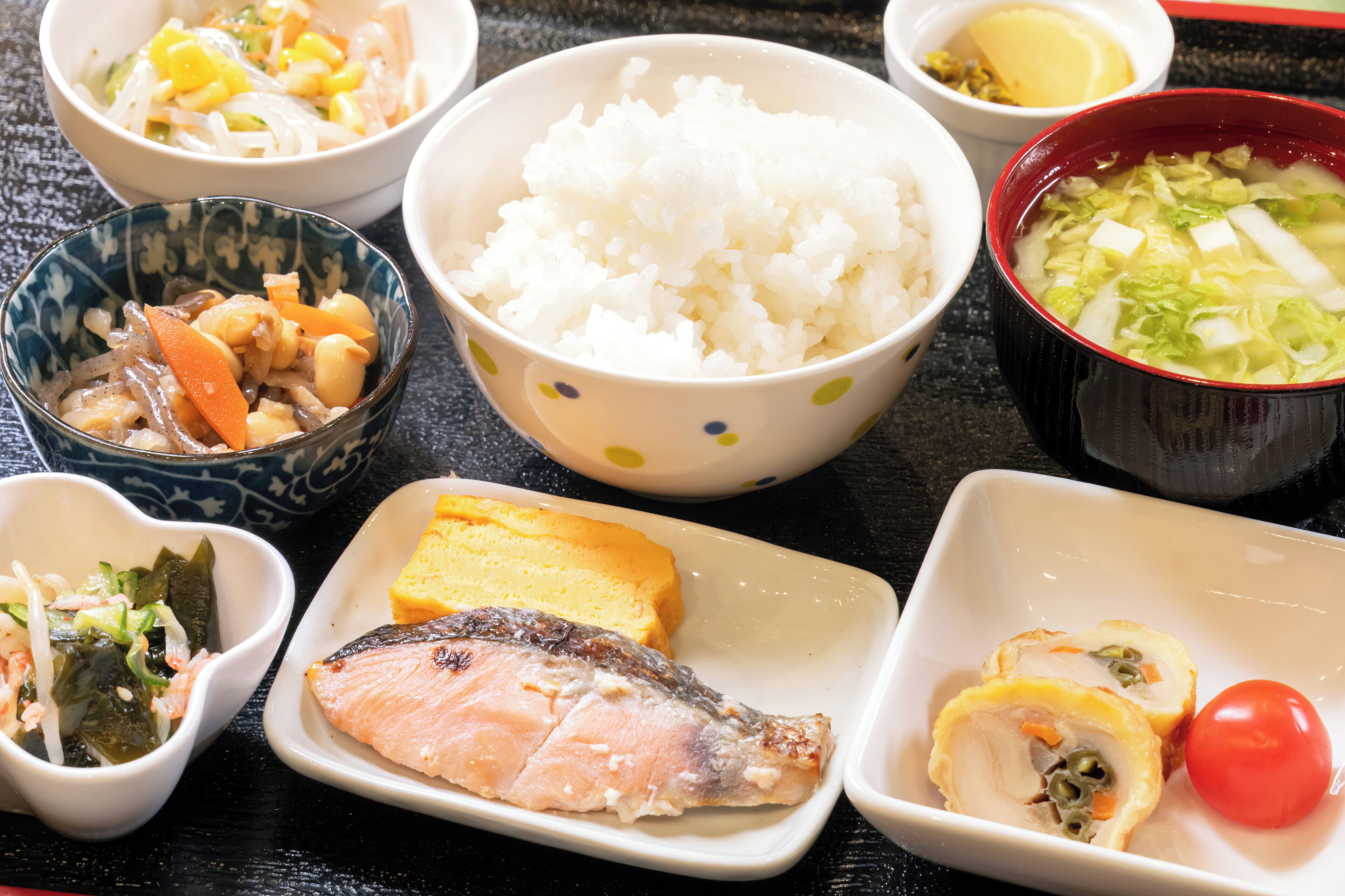 Un assortiment de plats comprenant du riz, du poisson et des légumes.