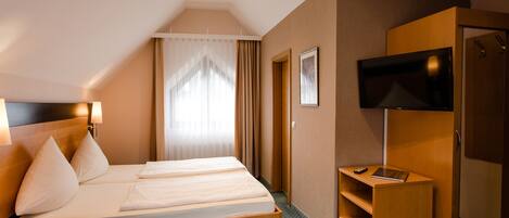 Una habitación de hotel con cama, televisión, escritorio y armario.