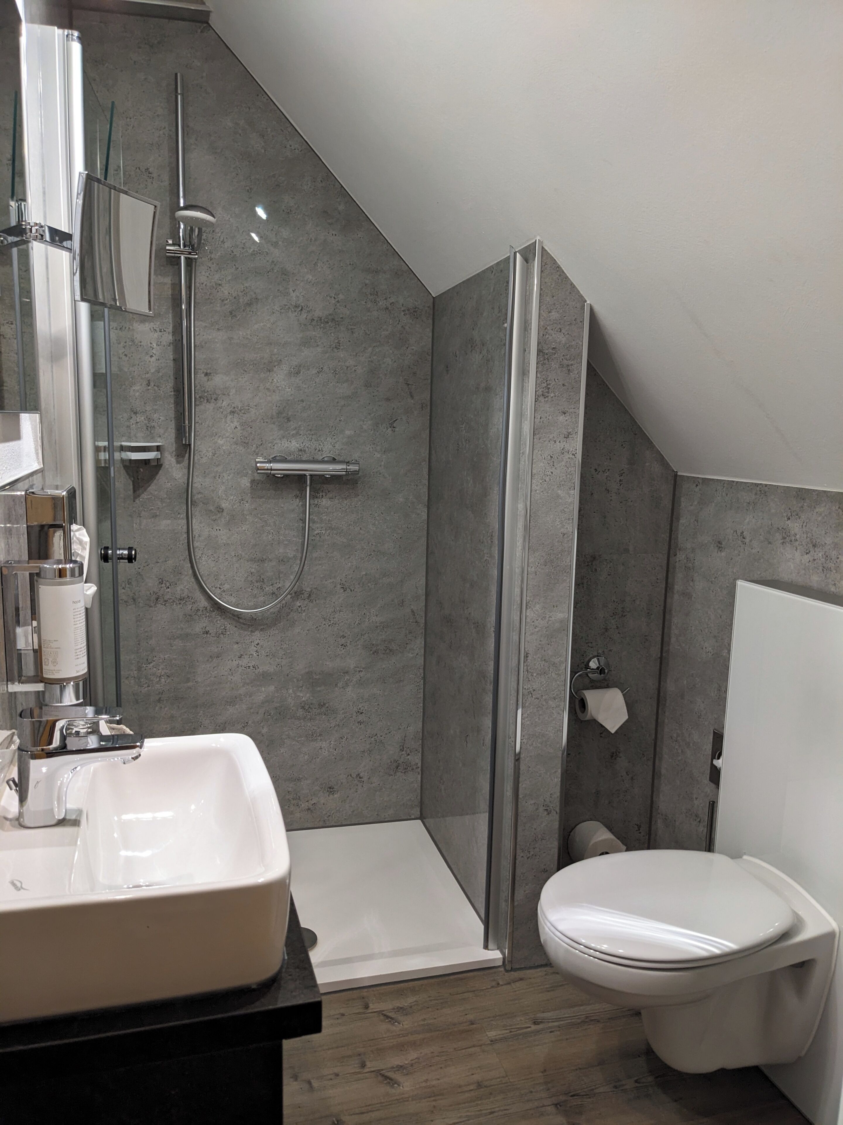 Un baño moderno con ducha, inodoro y lavabo.