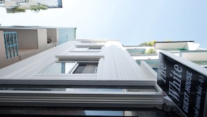 A modern building with a sign reading "The White Guest House." - The White House (Ho Chi Minh City)
