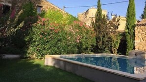 A swimming pool surrounded by lush greenery and stone buildings. - Les Aiguières en Provence (Suze-la-Rousse)