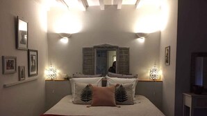 A bedroom with a bed, two bedside lamps, a mirror, and framed pictures on the wall. - Les Aiguières en Provence (Suze-la-Rousse)