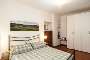 A bedroom with a bed, a nightstand, a lamp, a wardrobe, and a painting on the wall. - Casa Zeffiro, two minutes walk from Trevi Fountain (Roma)
