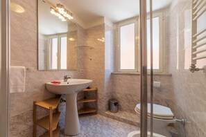 A modern bathroom with a pedestal sink, a glass shower enclosure, and a toilet. - Casa Zeffiro, two minutes walk from Trevi Fountain (Roma)