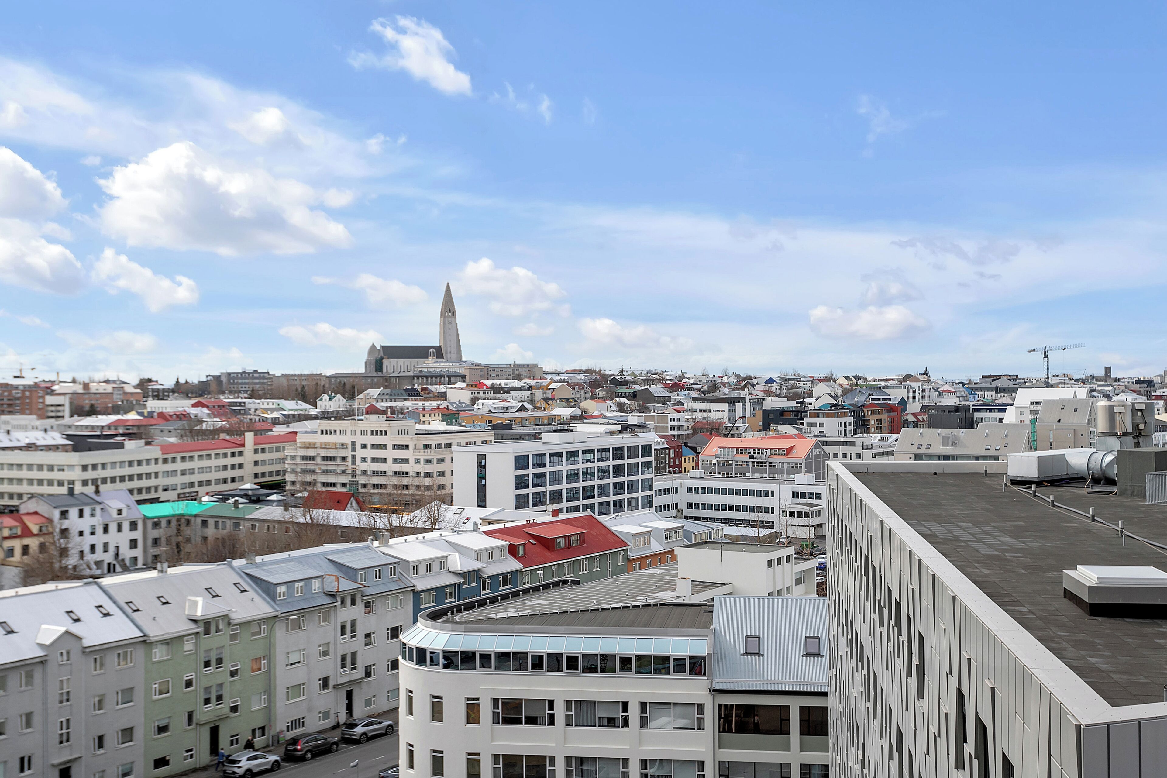 A cityscape with modern buildings, a prominent tower, and a clear sky.