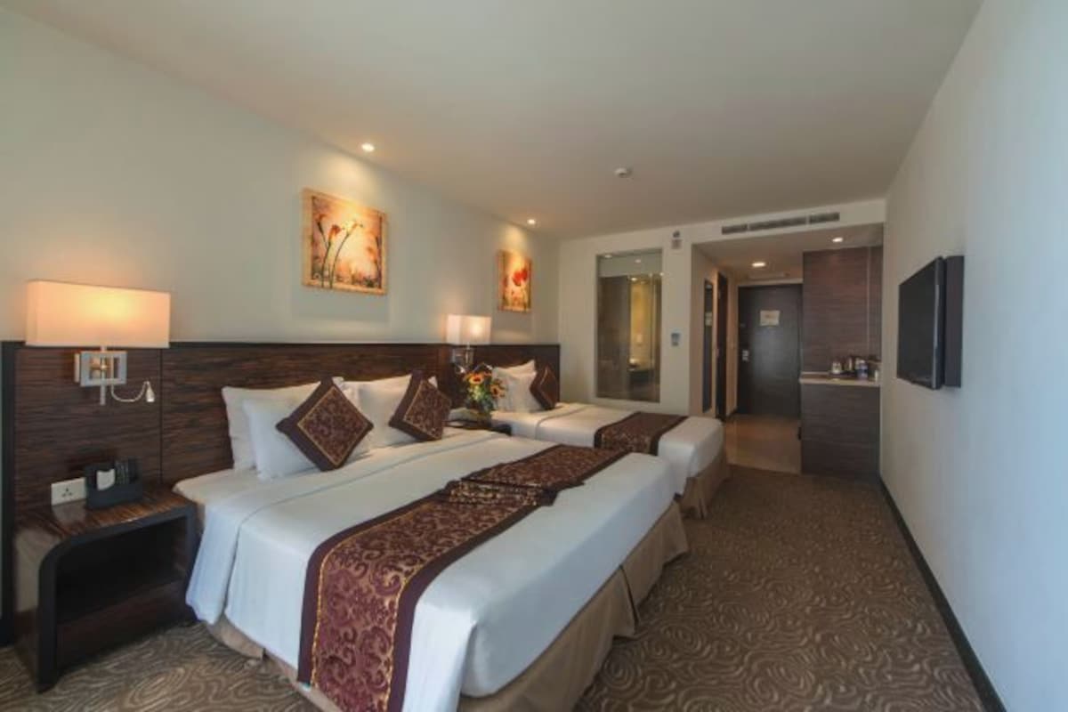 Une chambre d’hôtel avec deux lits, une table de chevet, une lampe et des œuvres d’art accrochées aux murs.