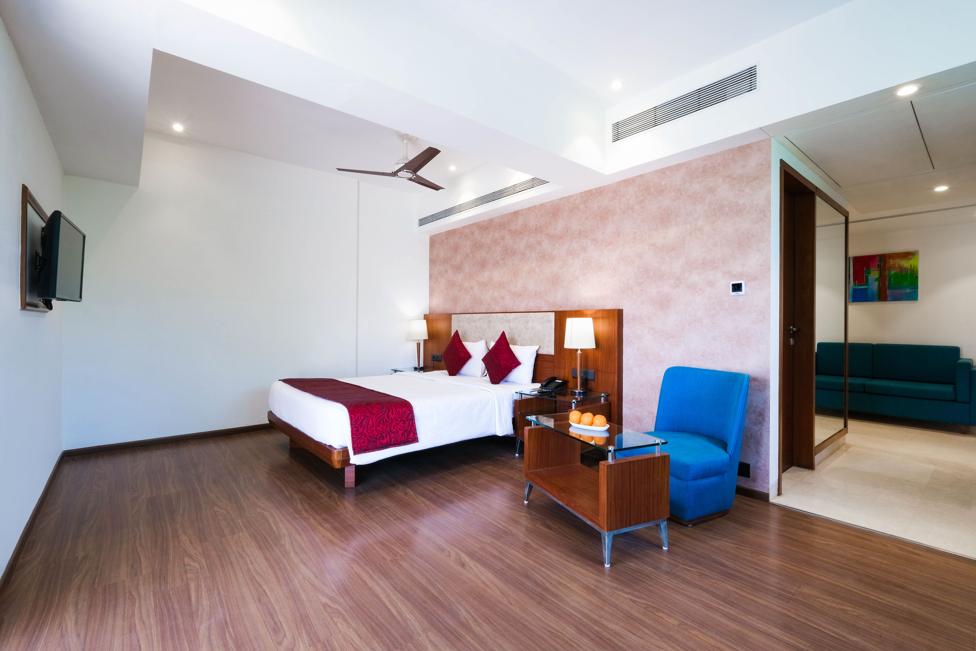 Una habitación de hotel moderna con cama, escritorio, silla y televisor.