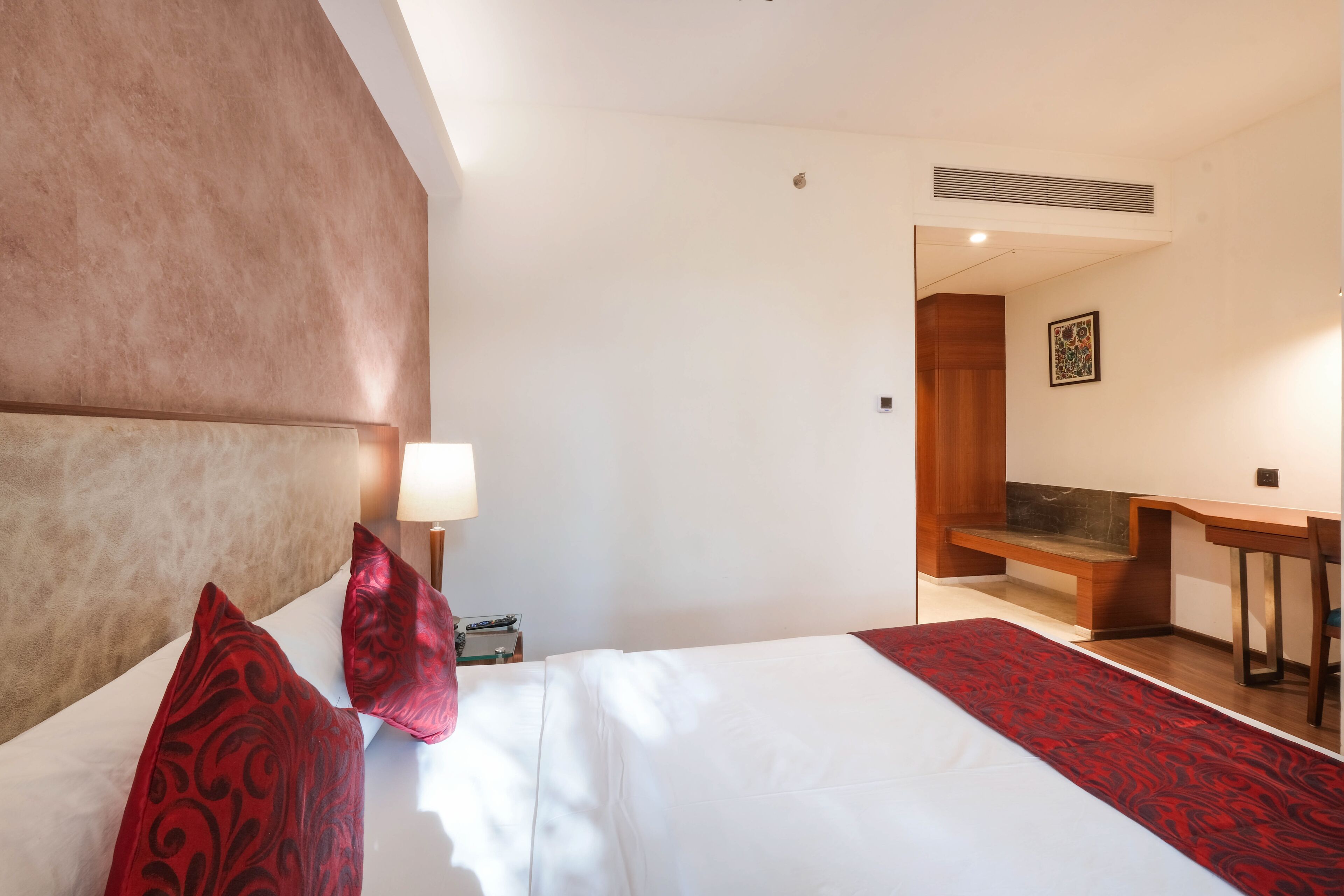 Ein Hotelzimmer mit einem großen Bett, einem Schreibtisch und einem Sessel.